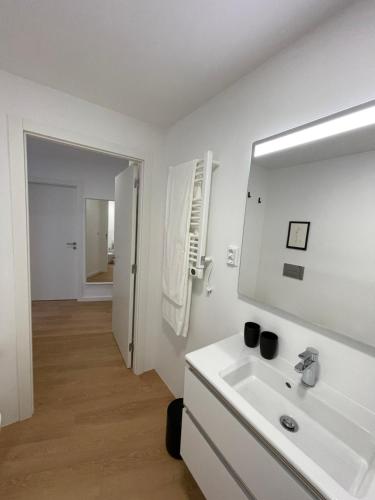 Baño blanco con lavabo y espejo en Living PDL 2, en Ponta Delgada