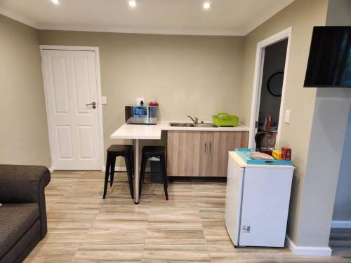 a kitchen with a table with chairs and a refrigerator at Knysna Holiday Armadillo in Knysna