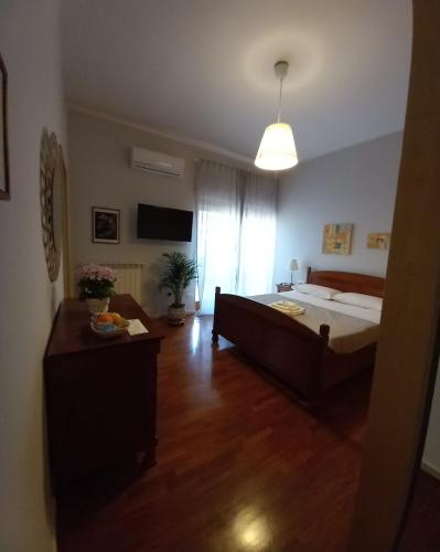 a bedroom with a large bed and a television at Le Stanze di Nonna Lina in Pagani