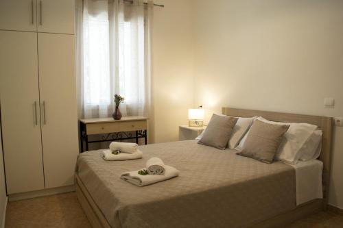 a bedroom with a bed with towels on it at Helia Apartment 1 in Alepou