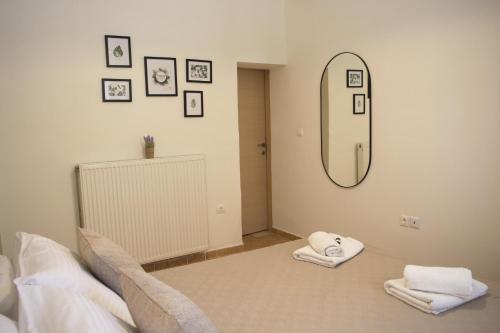 a bedroom with a mirror and towels on a bed at Helia Apartment 1 in Alepou
