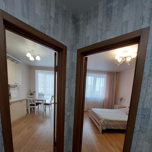 a bedroom with a bed and a dining room with a table at Новобуд з кондиціонером ЖК "Яровиця 11" in Lutsk