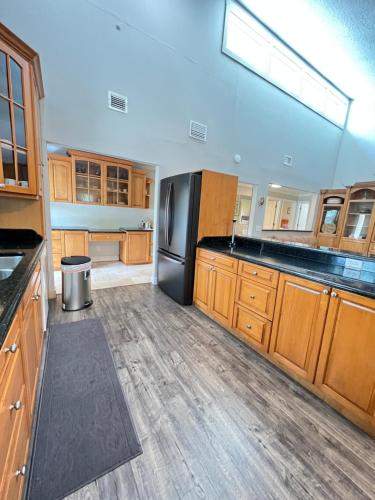 a kitchen with wooden cabinets and a black refrigerator at Resort Like house, 4 bedrooms, 3 bathrooms in Orlando