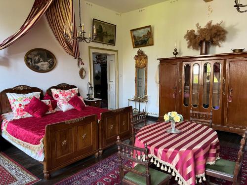 ein Schlafzimmer mit einem Bett und einem Tisch mit Blumen darauf in der Unterkunft Park Villa Reichenbach in Reichenbach