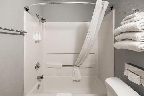 een badkamer met een bad, een toilet en handdoeken bij Sutter Inn in Yuba City