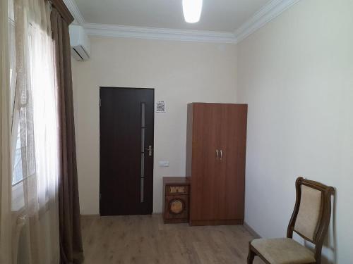 a room with a door and a chair and a cabinet at Yeganyans Guest House and Wine Yard in Ashtarak