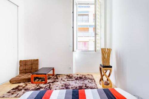 une chambre avec un lit, une chaise et une fenêtre dans l'établissement Room rental in apartment in Marseille, à Marseille