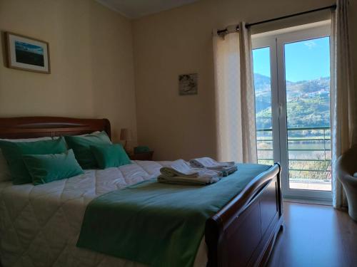 a bedroom with a bed with green sheets and a window at Vineyards Valley House in Penajoia
