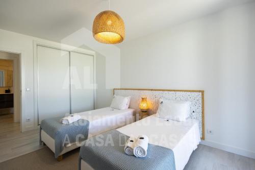 1 dormitorio con 2 camas, mesa y lámpara en Bluevillas Ribamar T1 by ACasaDasCasas - Apartment 1, en Ericeira