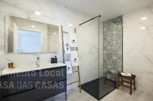 y baño con lavabo y ducha con espejo. en Bluevillas Ribamar T1 by ACasaDasCasas - Apartment 1, en Ericeira