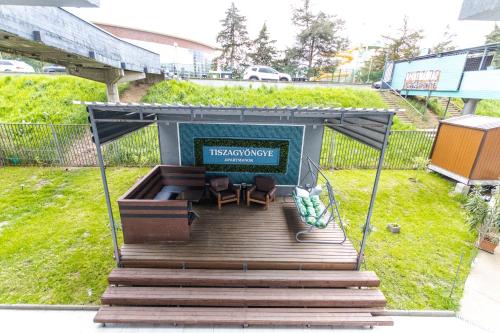 a small shelter with two chairs and a sign on it at Tisza Gyöngye Apartmanok in Szeged