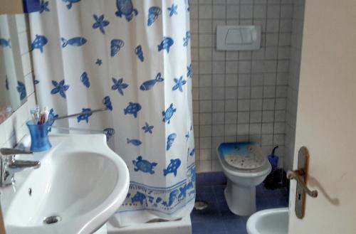 a bathroom with a sink and a toilet and a shower curtain at Gaeta Villino Isabella in Gaeta