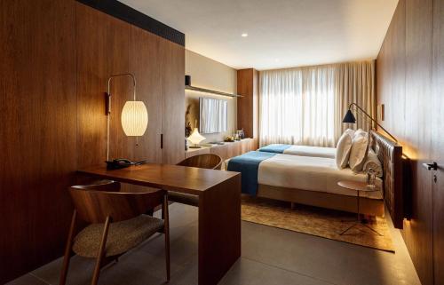聖保羅的住宿－Hotel Fasano Sao Paulo Itaim，酒店客房配有一张床铺、一张桌子和一张书桌。