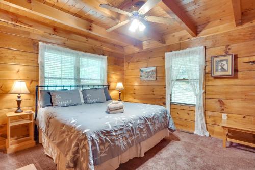 a bedroom with a bed in a log cabin at Cabin with Hot Tub about 6 Mi to Downtown Gatlinburg! in Gatlinburg