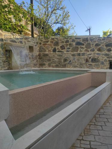 a swimming pool with a waterfall in a stone wall at Fairytale Elafonisi in Perivólia