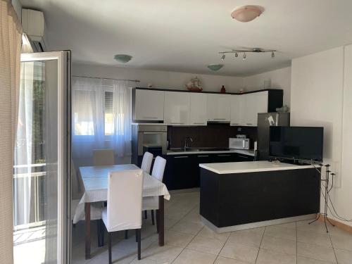 a kitchen with a table and a dining room at Mare in Brodarica