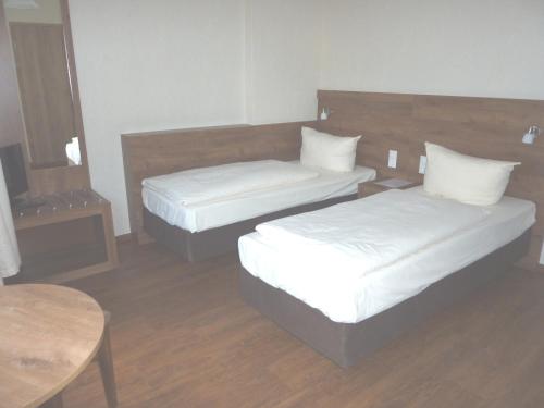 a room with two beds and a table at Hotel am Markt Sankt Goar in Sankt Goar