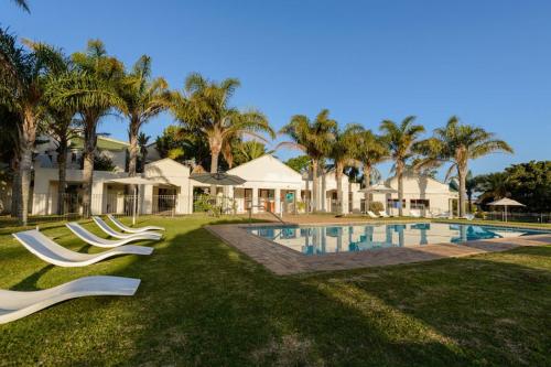 a resort with a swimming pool and palm trees at Mount Castleton in Plettenberg Bay