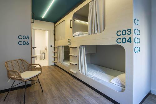 a room with two bunk beds and a chair at Bulezen Urban Hostel in Pontevedra