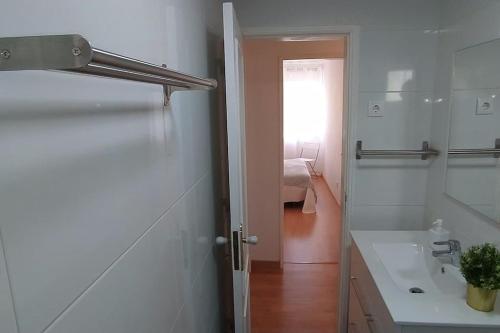 Baño blanco con lavabo y puerta en Lisboa/City/Sunny Apar/Metro/Airport/WiFi/Air Cond en Lisboa