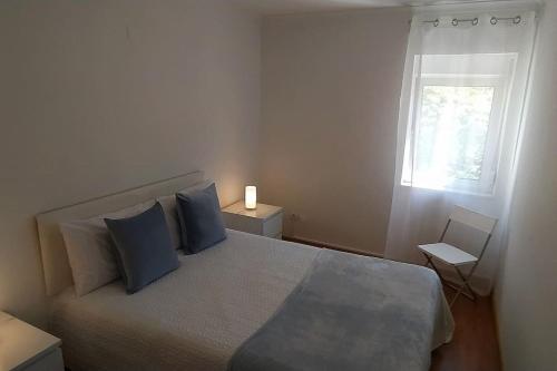 Un dormitorio con una cama con almohadas azules y una ventana en Lisboa/City/Sunny Apar/Metro/Airport/WiFi/Air Cond en Lisboa