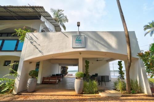 a view of the entrance to a hotel with palm trees at Blu Missel By The River in Panaji