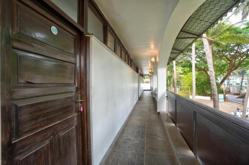 a hallway with a wooden door and a sidewalk at Blu Missel By The River in Panaji