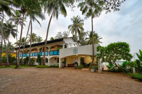 an exterior view of a building with palm trees at Blu Missel By The River in Panaji
