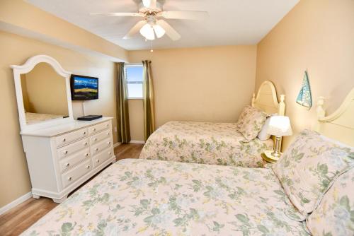 een slaapkamer met 2 bedden en een dressoir met een spiegel bij Sandpiper 1A in Gulf Shores