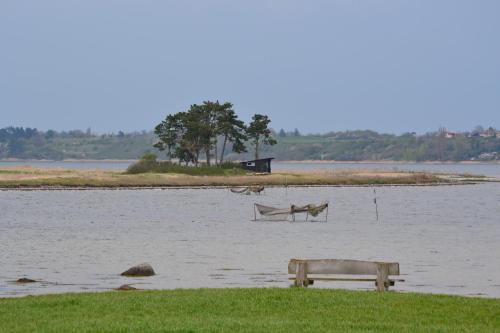 a bench in the middle of a body of water at Holbæk. Byhus med fjordudsigt, og 5 min. til bymidten in Holbæk