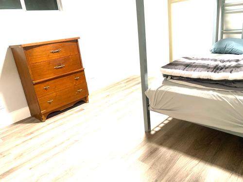 a bedroom with a bed and a wooden dresser at Three Zzz’s in Houston