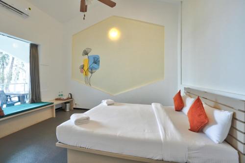 a bedroom with a bed with a painting on the wall at Blu Missel By The River in Panaji