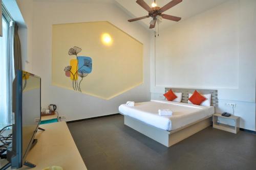 a bedroom with a bed with a painting on the wall at Blu Missel By The River in Panaji