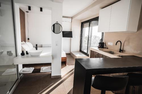 アテネにあるSuites with magical view & jacuzziの白いキャビネットと黒いテーブル付きのキッチン