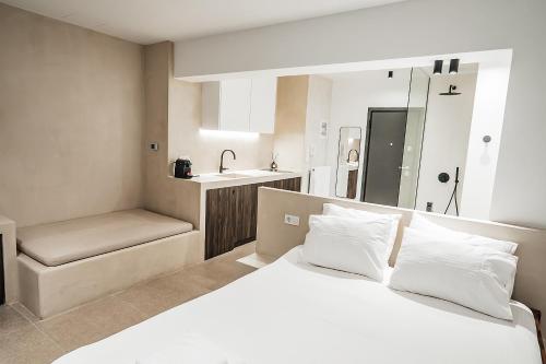 アテネにあるSuites with magical view & jacuzziのベッドルーム(白い大型ベッド1台、シンク付)