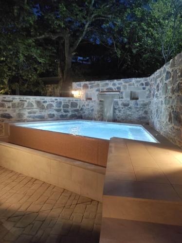 a large swimming pool with a stone wall around it at Fairytale Elafonisi in Elafonisi