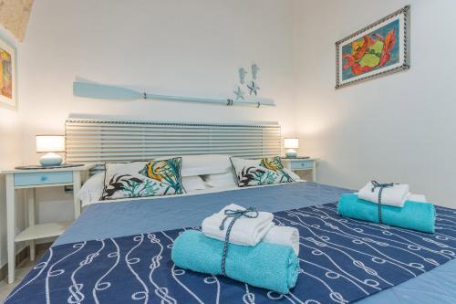a bedroom with a blue bed with towels on it at Extravacanza Spiraglio di Mare in Polignano a Mare