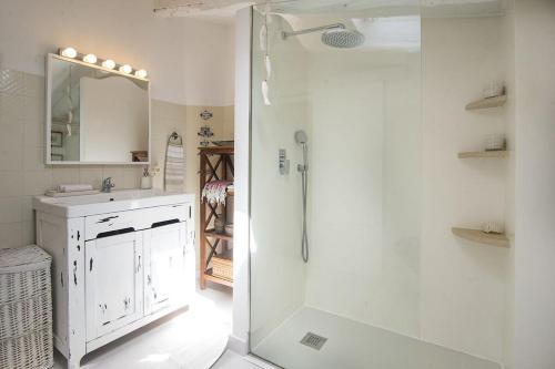 a white bathroom with a shower and a sink at Ca Na Mon in Ses Salines
