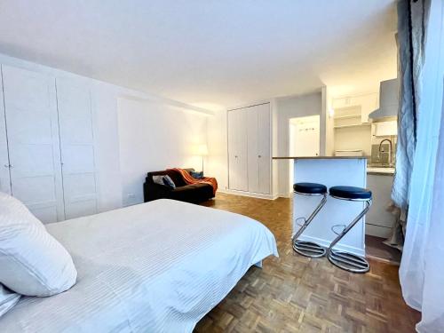 una camera con un letto bianco e due sgabelli di Tour Eiffel - Seine a Parigi