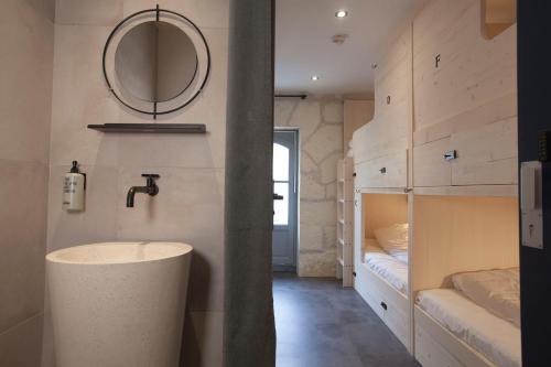La salle de bains est pourvue d'un lavabo et d'un miroir. dans l'établissement Le Maje Hostel, à Montpellier