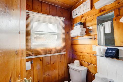 a bathroom with wooden walls and a toilet and a window at Lodge at Poncha Springs in Salida