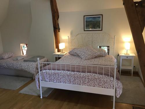 sypialnia z łóżkiem, dwoma stołami i dwoma lampami w obiekcie La Lézardière w mieście Épeigné-les-Bois