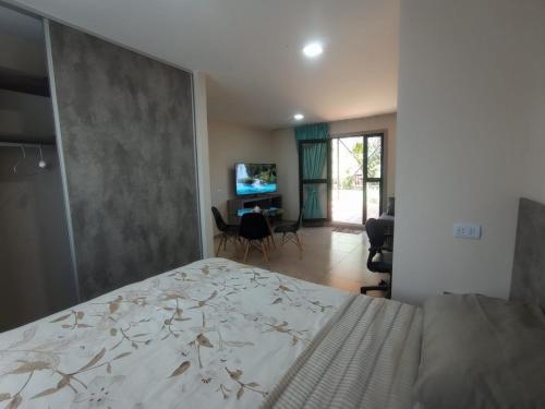 1 dormitorio con 1 cama y sala de estar en Tres Chihuahuas & Spa en Mariano Moreno