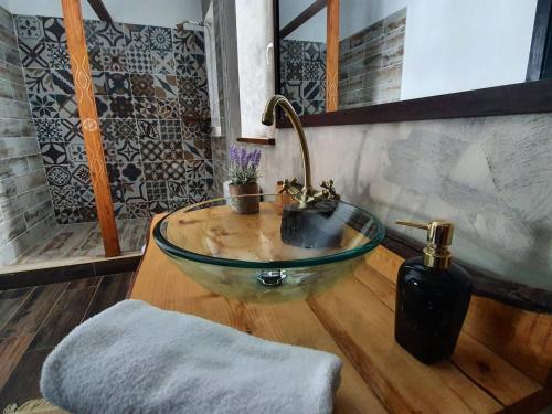 a bathroom with a glass bowl sink with a faucet at Casa meșterului in Sohodol