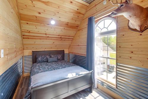 a bedroom with a bed in a log cabin at Cozy Alabama Retreat with Hot Tub, Near Ruby Falls! in Bryant