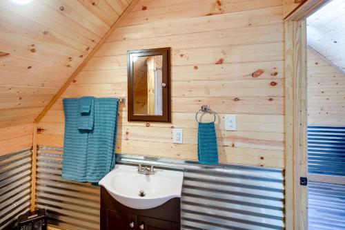 a bathroom with a sink and a mirror at Cozy Alabama Retreat with Hot Tub, Near Ruby Falls! in Bryant