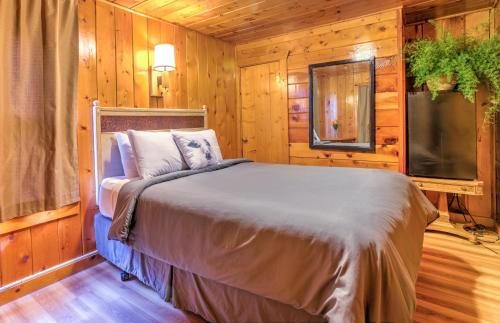 a bedroom with a bed and a tv and wooden walls at Lodge at Poncha Springs in Salida