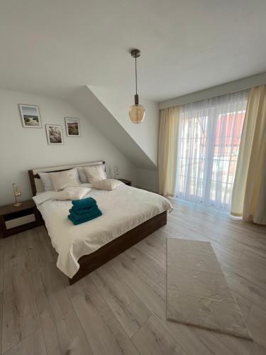 a bedroom with a large bed and a large window at GOLDEN Residence in Łeba