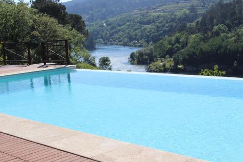 a swimming pool with a view of a river and mountains at "Bouça Drigues" Casa antiga de pedra com piscina e vista rio in Amarante