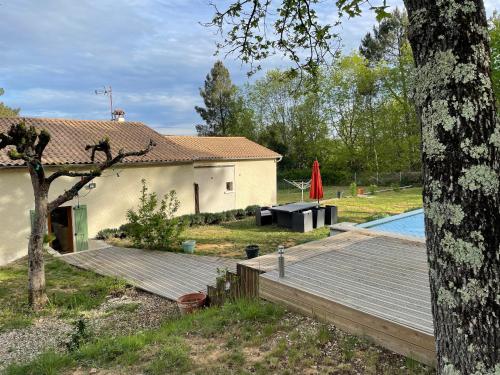 une arrière-cour avec une maison et une piscine dans l'établissement Maison des Pins, à Salavas